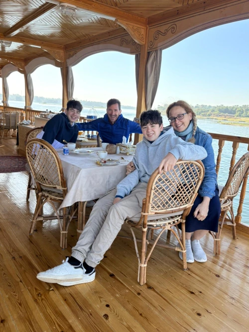 Familia desayunando en la cubierta de una dahabeiya durante un crucero por el Nilo